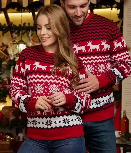 Couple wearing matching red knit Christmas sweaters with reindeer patterns.