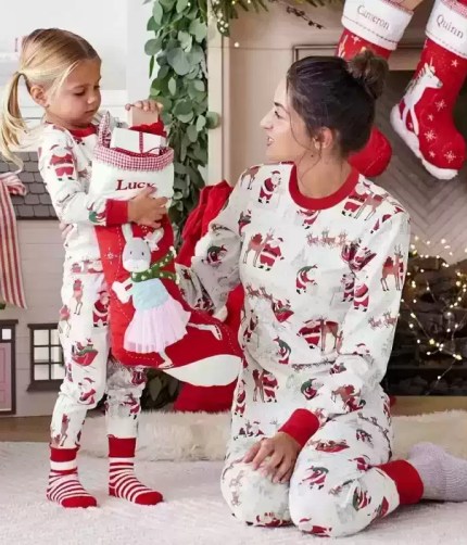 Mother and daughter in matching Santa pajamas.
