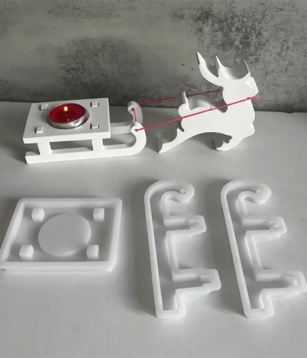 Silicone mold set for making a Christmas reindeer and sleigh candle holder.