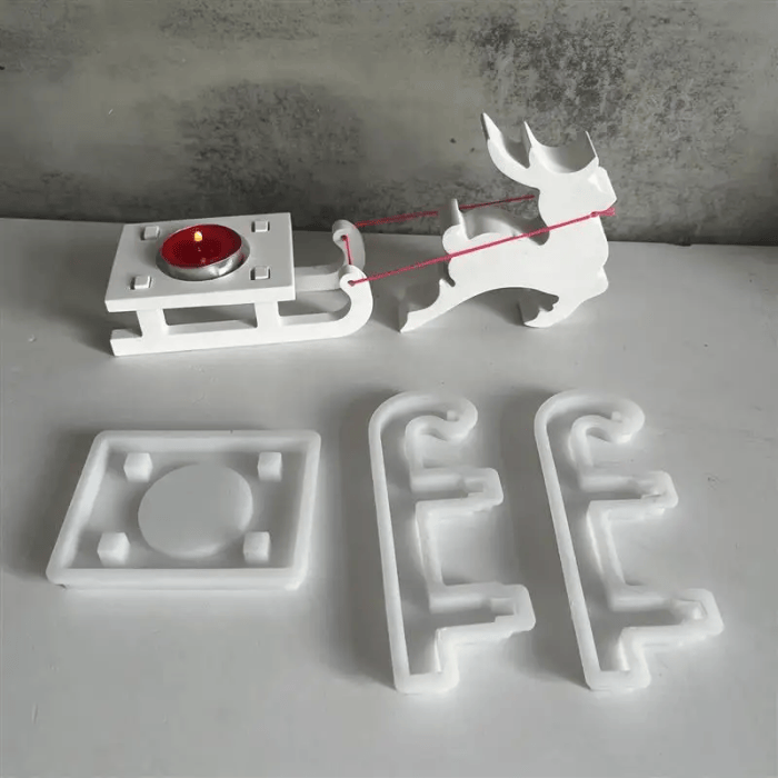 Silicone mold set for making a Christmas reindeer and sleigh candle holder.