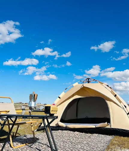 FJK Camping Gear quick-opening tent set up in a sunny park.