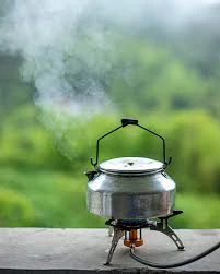 Camping kettle boiling on portable stove
