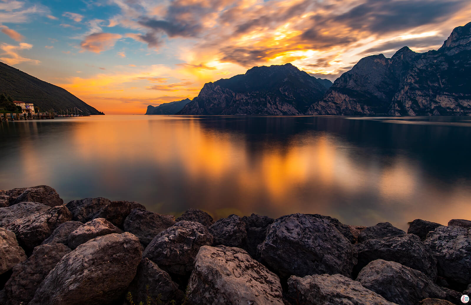 Sunrise over Lake Garda with calm water, surrounding mountains, and natural lakeside scenery near Del Garda Village camping site