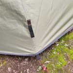 A hunter setting up the tipi hot tent in a dense forest for a hunting trip.