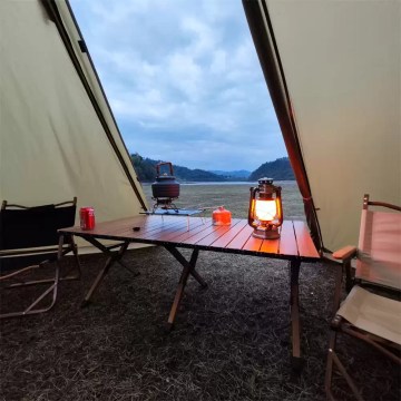 Cosy bell tent setup with camping table and lantern, perfect for UK glamping breaks