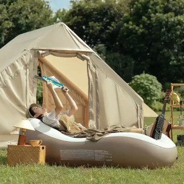 Inflatable camping chair used outside a tent for relaxing at the campsite