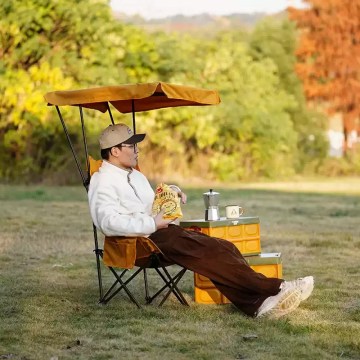 Outdoor folding canopy chair in use, comfortable camping chair for relaxing outdoors