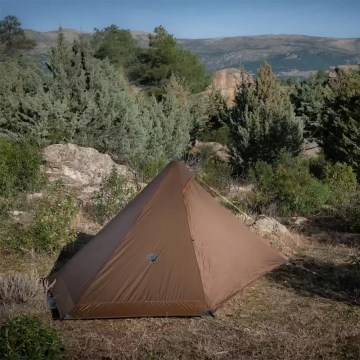 Lightweight brown camping tent pitched in countryside, ideal for UK hiking and wild camping trips 