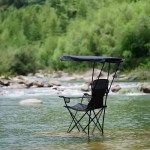 Two thick black roof armchairs set up for a sunny fishing trip.