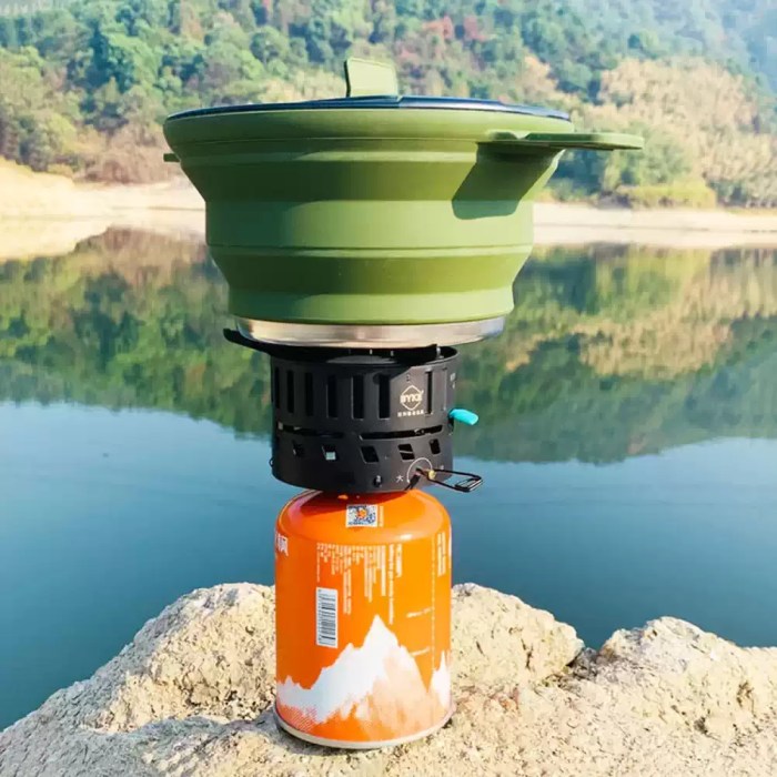 Secure locking handle on a portable boiling pot with a transparent lid for monitoring meals on family camping trips.