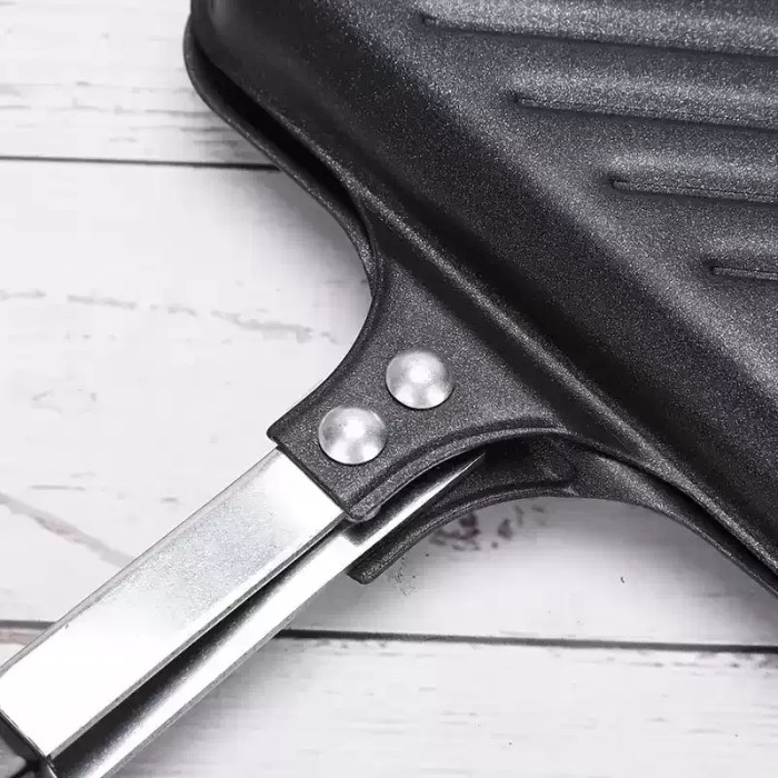 Secure locking handle on a portable sandwich toaster with heat-resistant grips for motorhome use.