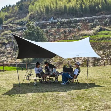 Naturehike tarp shelter setup with campers enjoying outdoor picnic under sun shade in UK