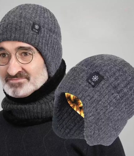 Dark grey ribbed knit winter beanie hat with integrated ear flaps, worn with a matching neck warmer, shown alongside an angled view revealing the warm inner lining