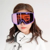 Woman wearing red and purple mirrored ski goggles with a white winter jacket