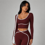 Close-up of women’s burgundy activewear set with contrast trim and crossover waistband