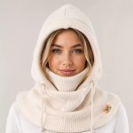 Woman wearing a cream knitted balaclava hood with adjustable drawstrings and full neck coverage for cold weather
