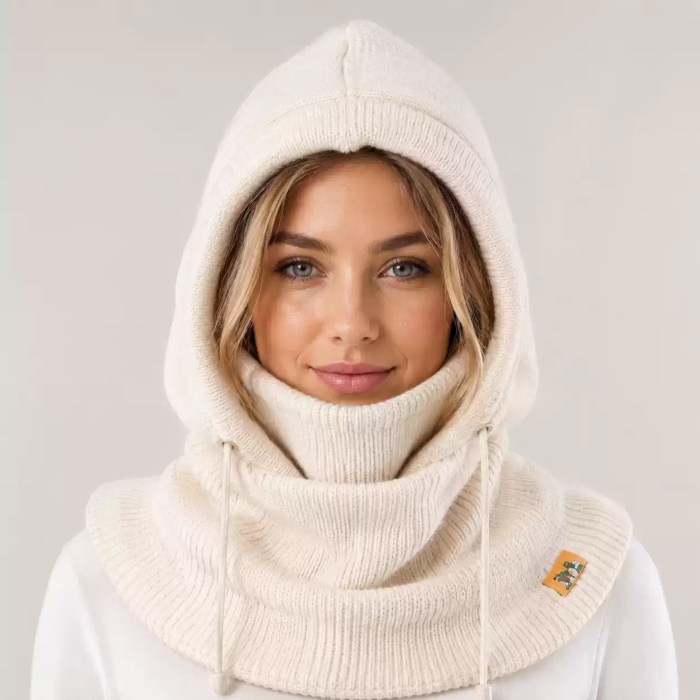 Woman wearing a cream knitted balaclava hood with adjustable drawstrings and full neck coverage for cold weather