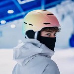 Person wearing a pink-to-blue gradient ski helmet with ear padding and black face covering for winter sports