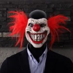 Scary clown Halloween mask with red hair and sharp teeth