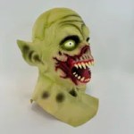 Side view of green zombie Halloween mask with pointed ear and scary teeth