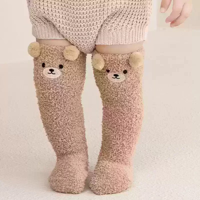 Beige kids knee-high winter socks with cute bear face.