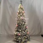 Flocked Christmas tree with warm lights and pink silver baubles.