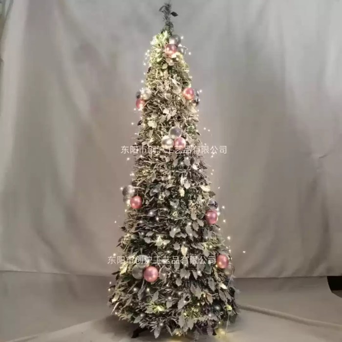 Flocked Christmas tree with warm lights and pink silver baubles.