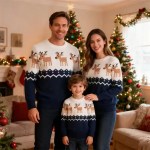 arents with their young son indoors wearing matching navy blue and white reindeer Christmas sweaters.