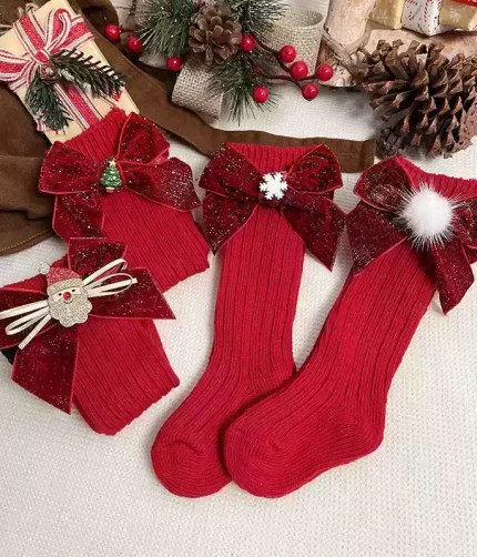 Red kids Christmas knee-high socks with festive bow decorations.