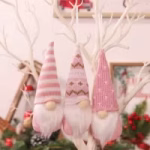 Three pink hanging Christmas gnomes with striped and patterned festive hats