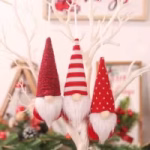 Three red hanging Christmas gnome decorations with striped and polka dot hats