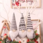 Three grey hanging Christmas gnomes with Nordic patterned festive hats